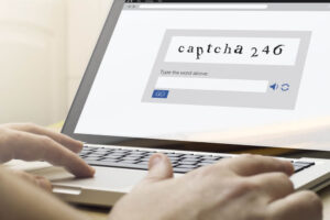 hand using a laptop with captcha on screen