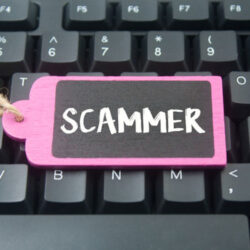 wooden tag written scammer over keyboard button background