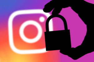 Instagram security concept. Silhouette of a hand holding a padlock infront of the Instagram logo