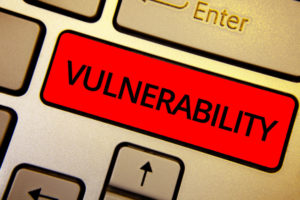 Text sign showing Vulnerability. Conceptual photo Information susceptibility systems bug exploitation attacker Keyboard brown keys yellow laptop idea create computer keypad laptop.