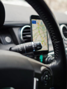 Car interior details Stalk switch on a background of a smartphone with navigation map, selective focus, vertical composition