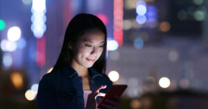 Woman send sms on cellphone at night