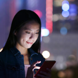 Woman send sms on cellphone at night