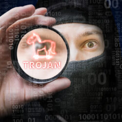 Masked anonymous hacker is cracking binary code with trojan malware.
